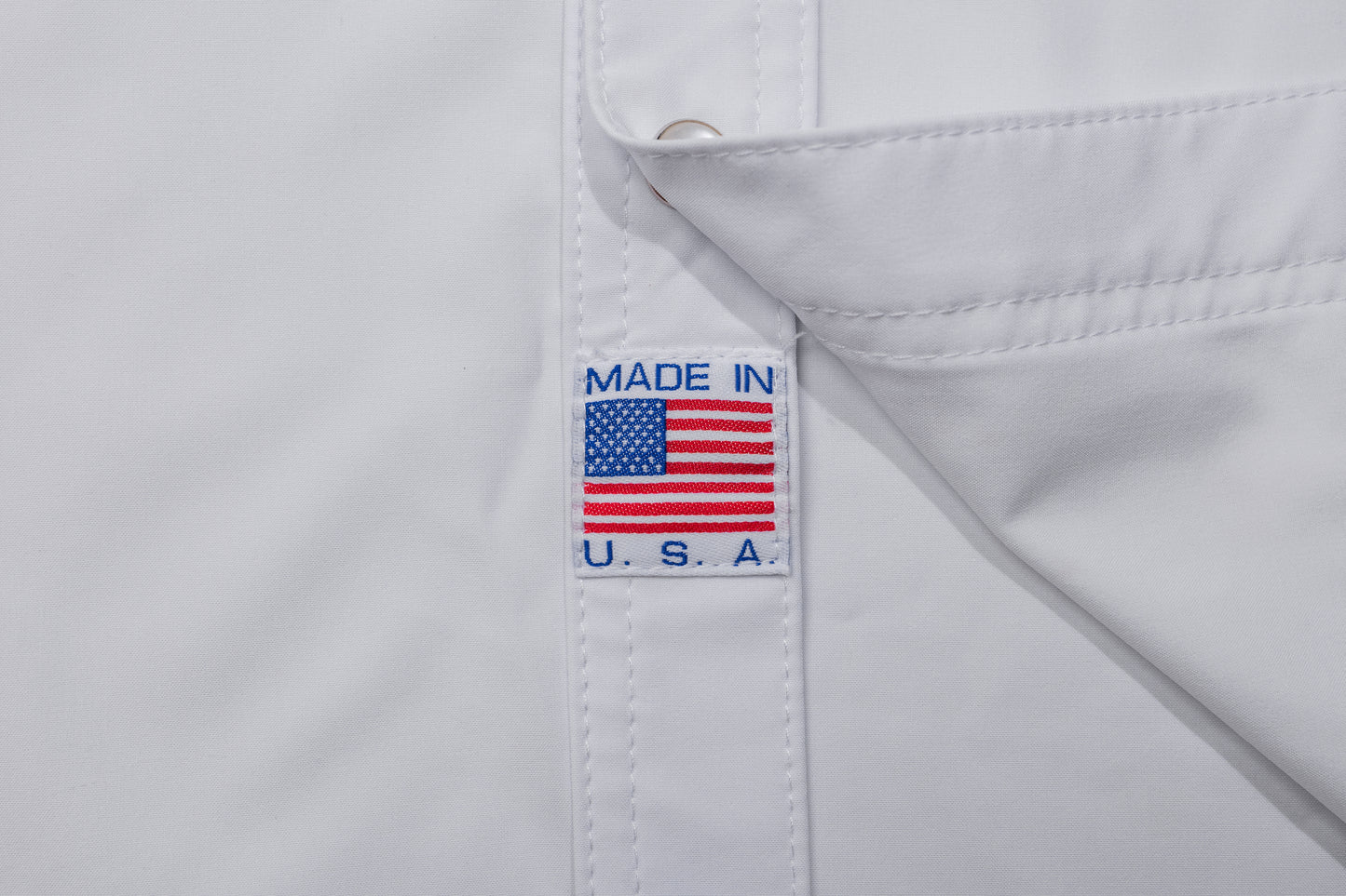 White shirt with 'Made in U.S.A.' label featuring an American flag on a white background