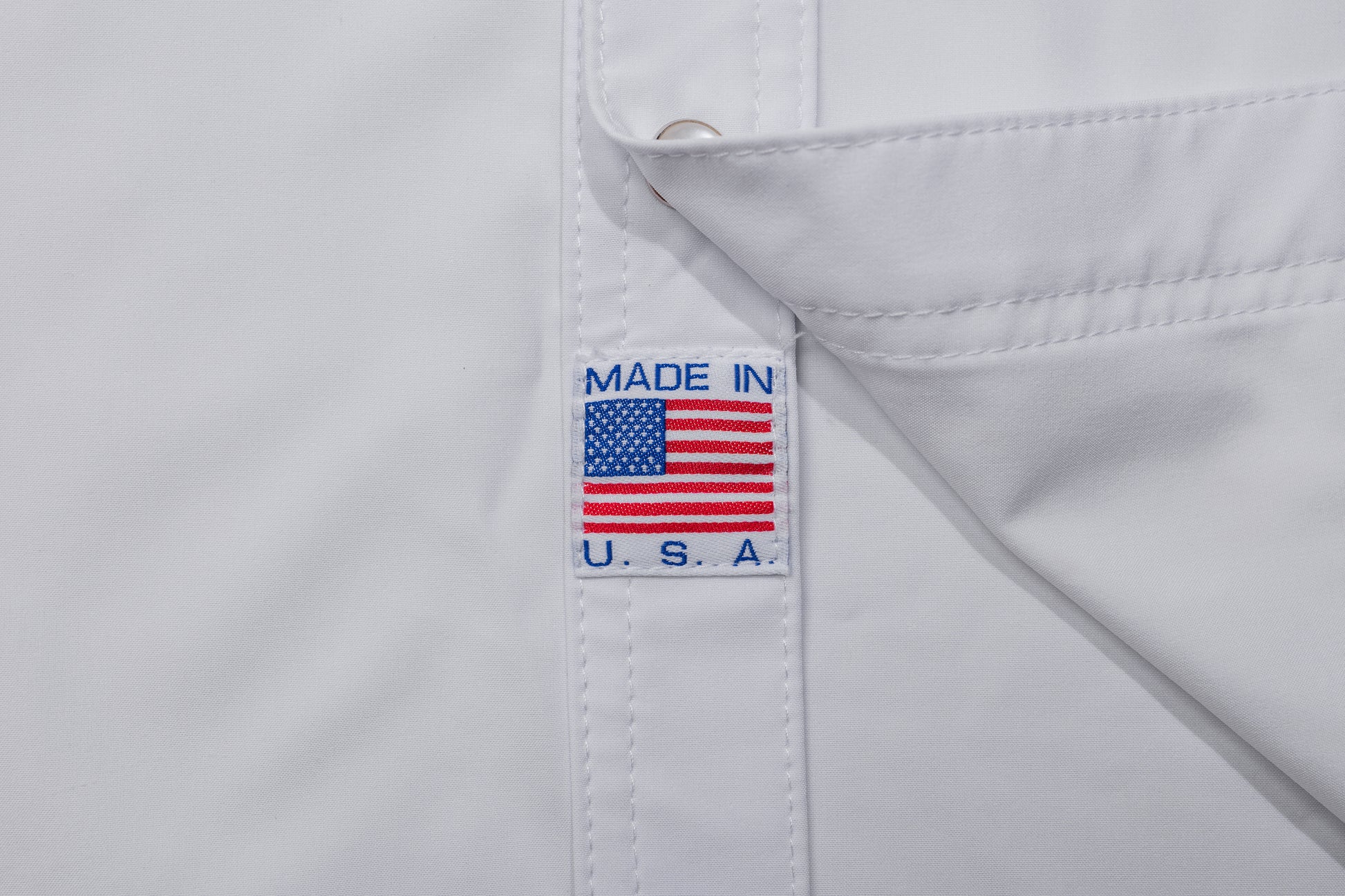 White shirt with 'Made in U.S.A.' label featuring an American flag on a white background