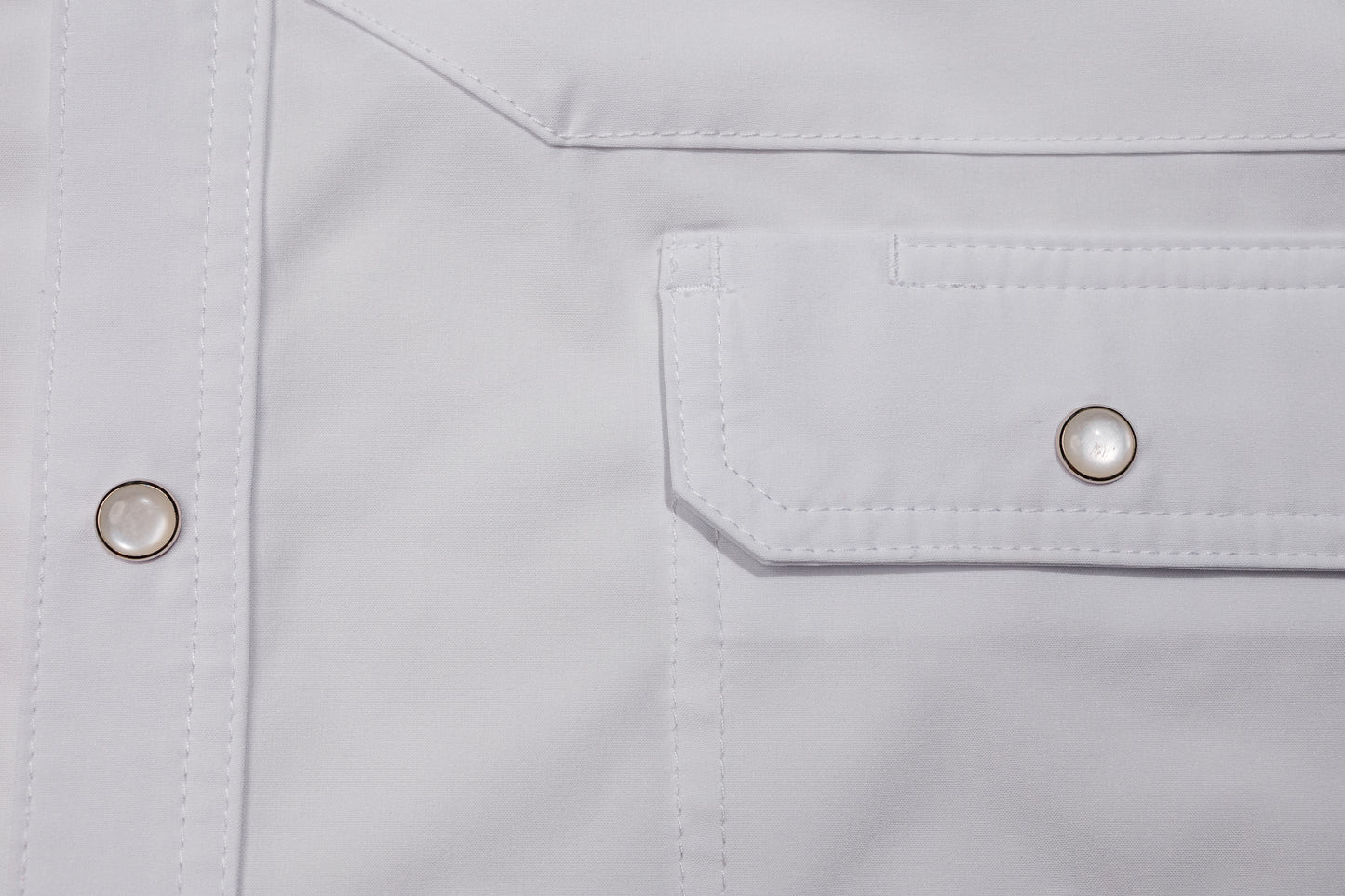 Close-up of a pearl snap pocket on a white shirt