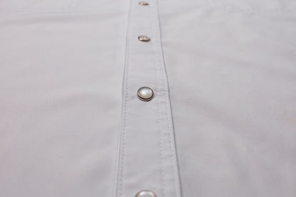 Close-up of a white shirt with pearl snaps on placket