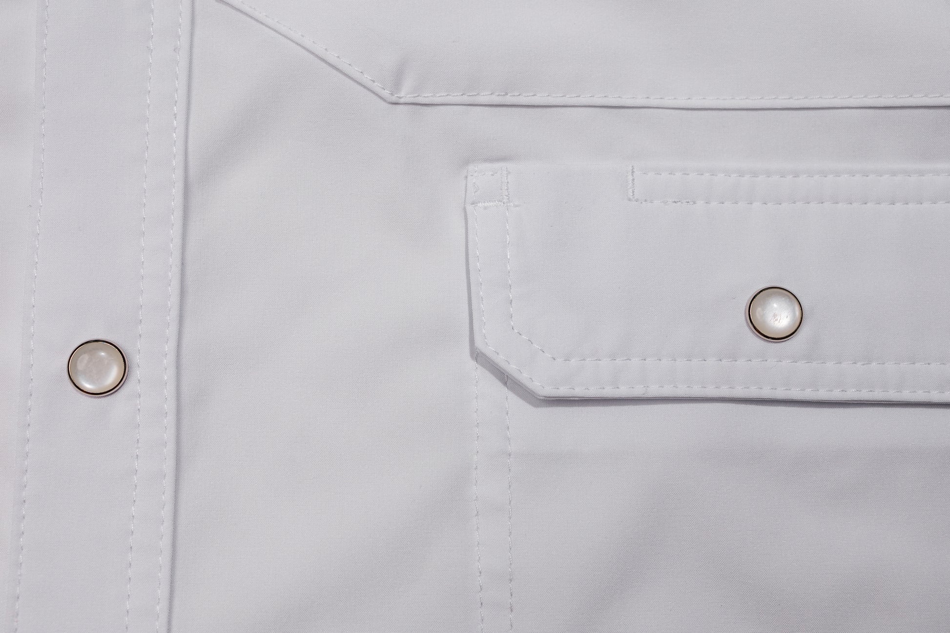 Close-up of a pearl snap pocket on a white shirt